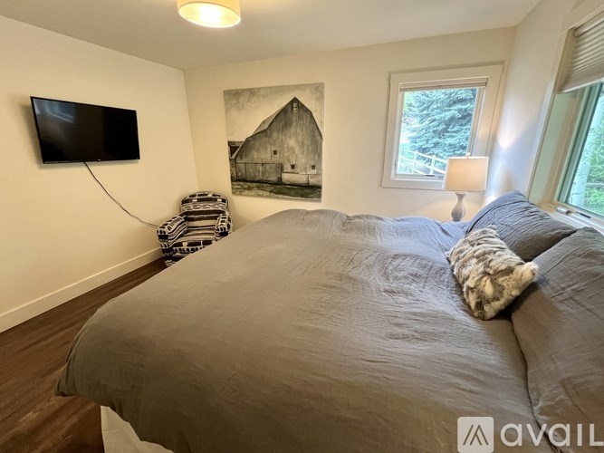 A bedroom with a large bed and a painting on the wall.