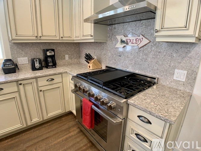 A kitchen with a stove top oven and a sign on the wall.