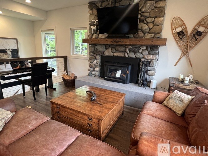 A living room with a fireplace and a TV above it.