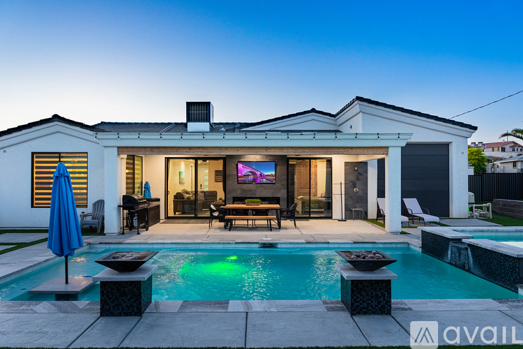 A house with a pool in front of it.