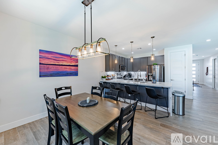 A modern kitchen with a wooden dining table and chairs.