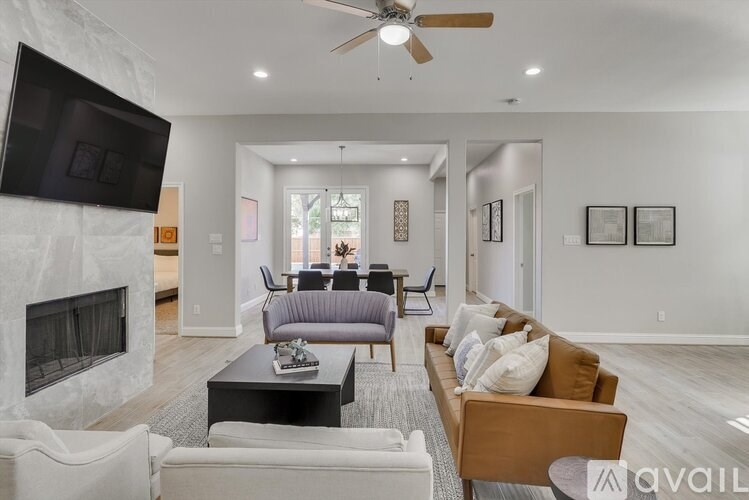 A living room with a fireplace and a television on the wall.