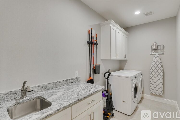 A kitchen with a sink, cabinets, and a washing machine.