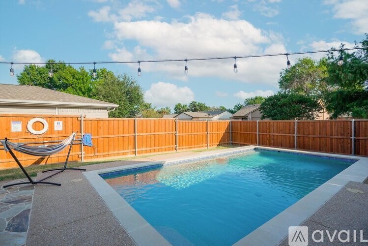A pool with a hammock and lights above it.