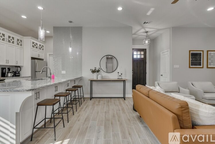 A modern kitchen with a bar area and a living room area.