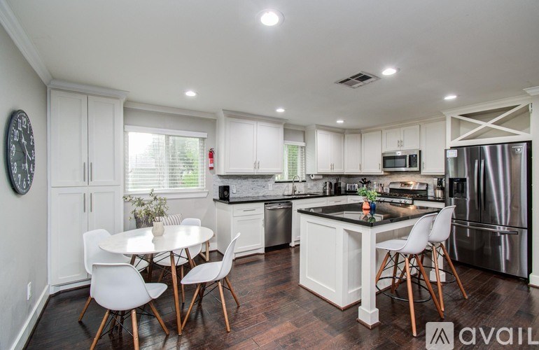 A spacious living room with a grey sofa and wooden flooring.