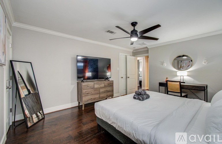 A bathroom with a sink, mirror, and shower.