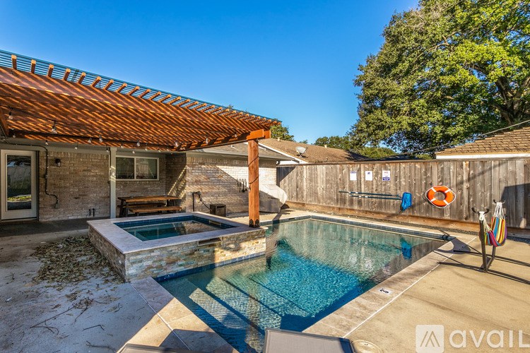 A pool with a slide and a house with a red roof.