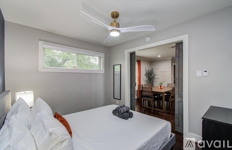 A backyard with a wooden swing set and a small house.