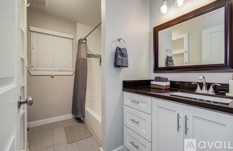 A pool with a slide and a wooden playhouse in the backyard.