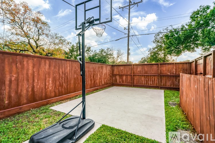 A backyard basketball court with a hoop and a black stand.