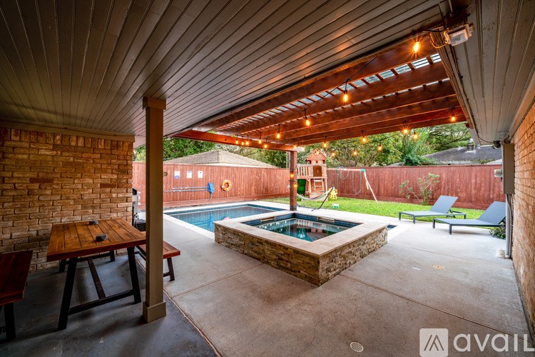 A patio with a table and chairs and a pool.