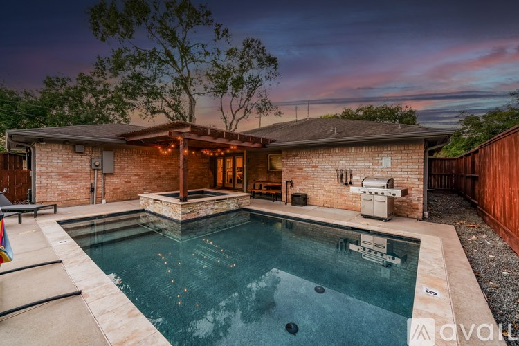A backyard with a pool and a house.