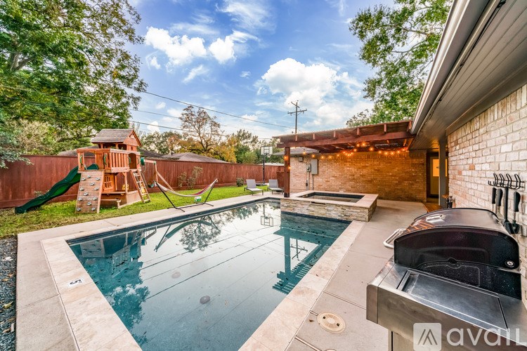 A backyard with a pool and a hot tub.