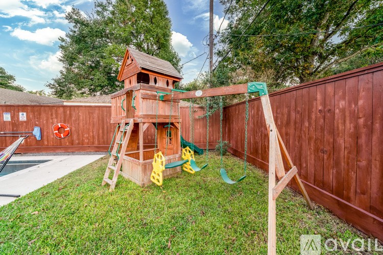 A wooden swing set in a backyard.