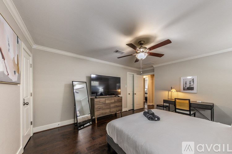 A bedroom with a bed, dresser, and television.