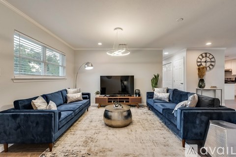 A living room with blue couches and a flat screen TV.