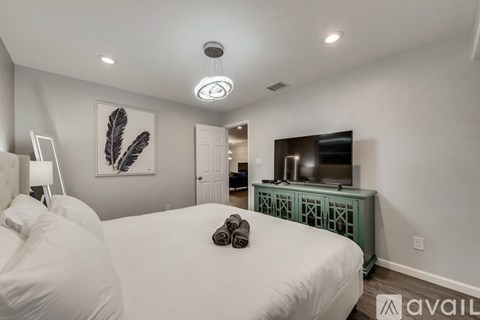 A bedroom with two beds and a television in the corner.