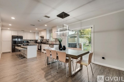 A modern kitchen with a dining table and chairs.