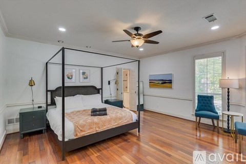 A bedroom with a four poster bed and a ceiling fan.