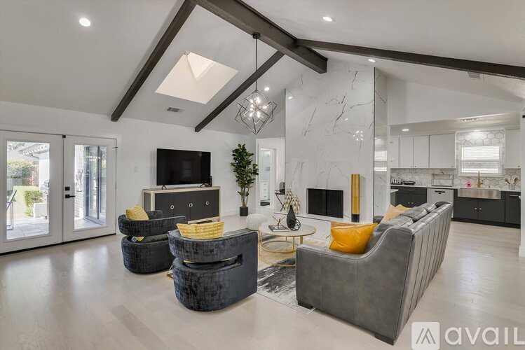 A modern living room with a grey sofa and a black television.