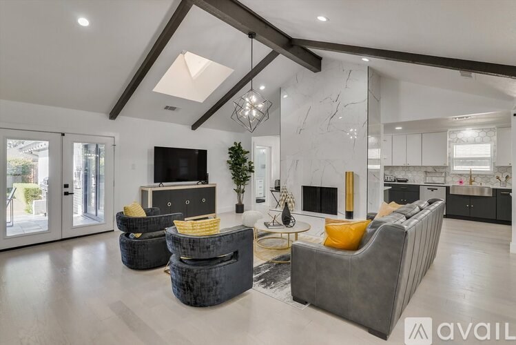 A modern living room with a grey sofa and a black television.