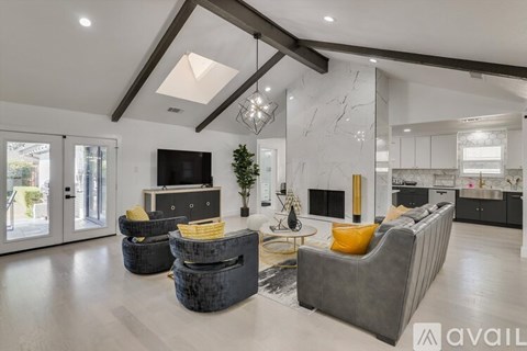 A modern living room with a grey sofa and a black television.