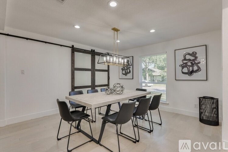 A dining room with a white table and black chairs.
