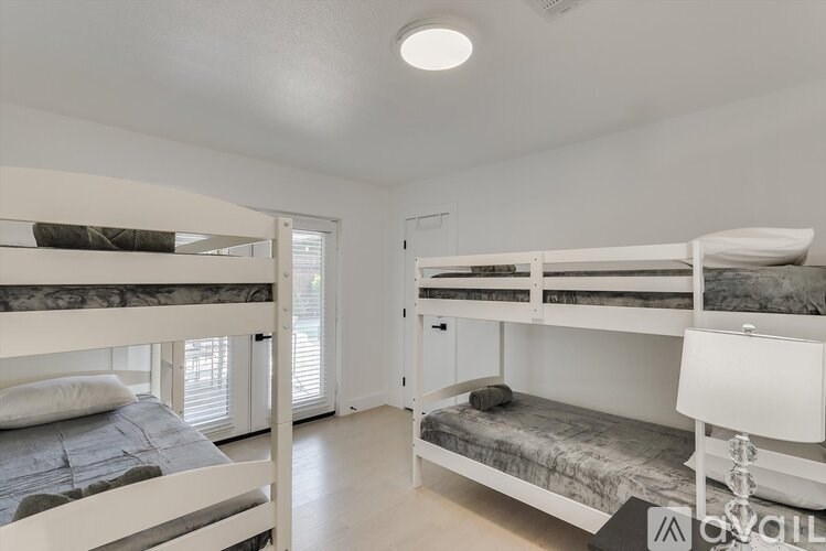A bedroom with white walls and a bunk bed.