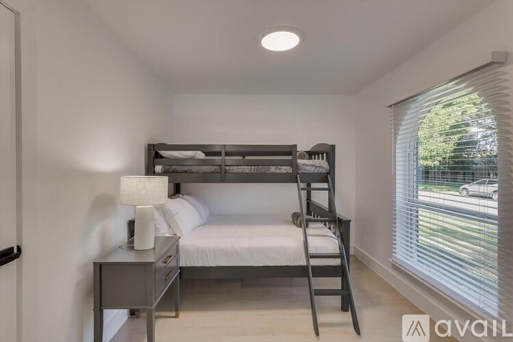 A bedroom with a bunk bed and a desk.