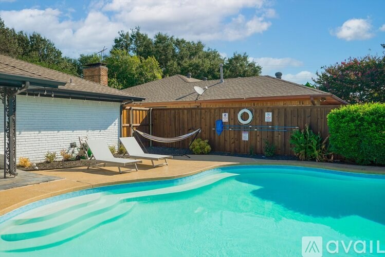 A pool in a backyard with a hammock and a house in the background.