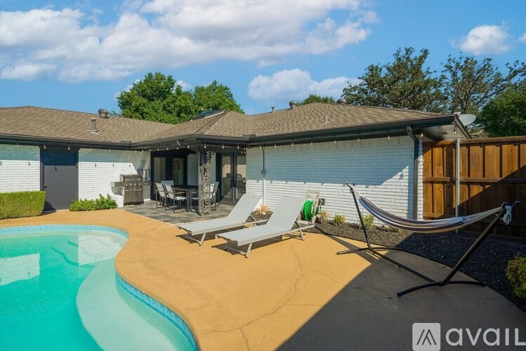 A backyard with a pool and a hammock.