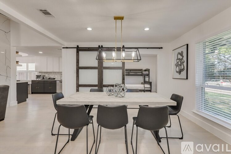 A modern dining room with a white table and chairs.