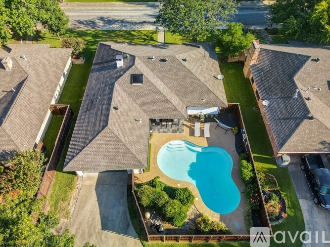 A bird's eye view of a residential area with houses and a swimming pool.