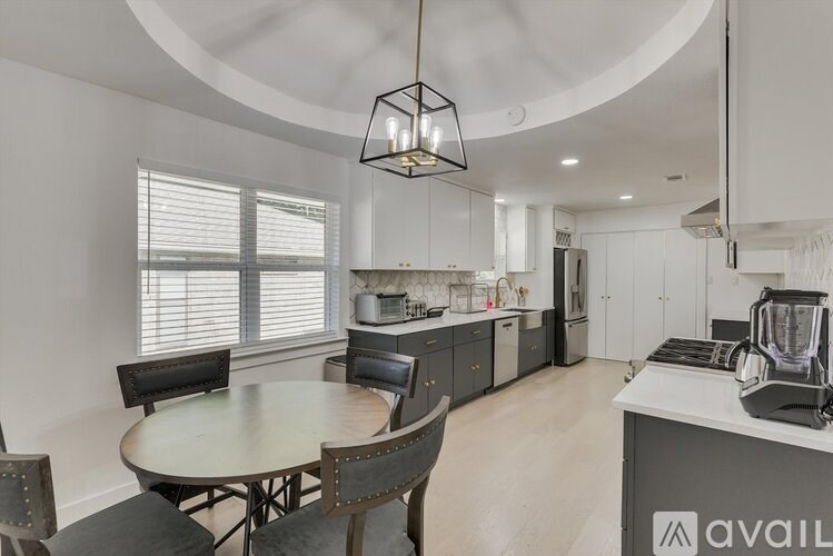A modern kitchen with a round table and chairs.