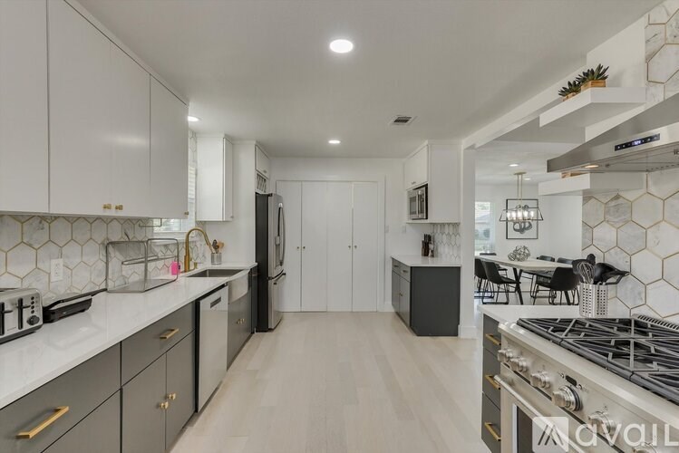 A modern kitchen with white cabinets and a black refrigerator.