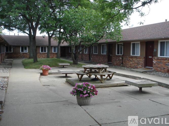 A courtyard with picnic tables and potted plants.