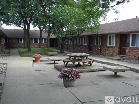 A courtyard with picnic tables and potted plants.