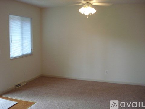A room with a ceiling fan and a window with blinds.