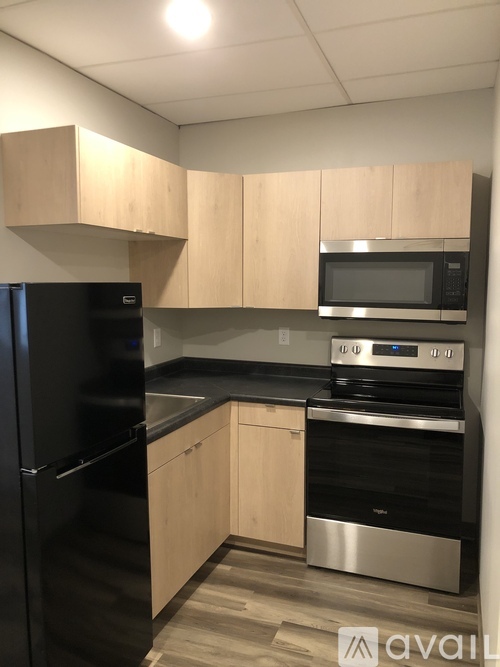 A kitchen with black appliances and wooden cabinets.