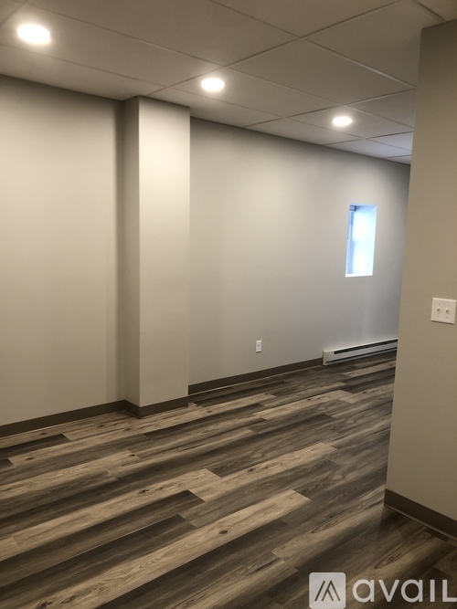 A room with wooden flooring and white walls.
