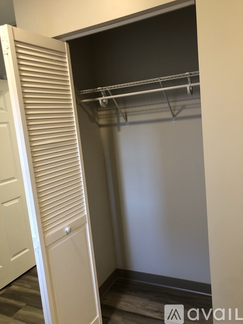 A white closet with a sliding door and a shelf.