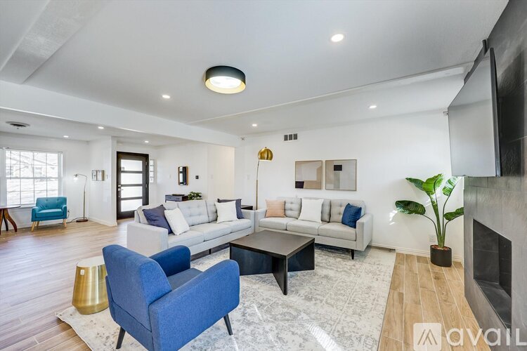 A living room with a blue chair and a white couch.