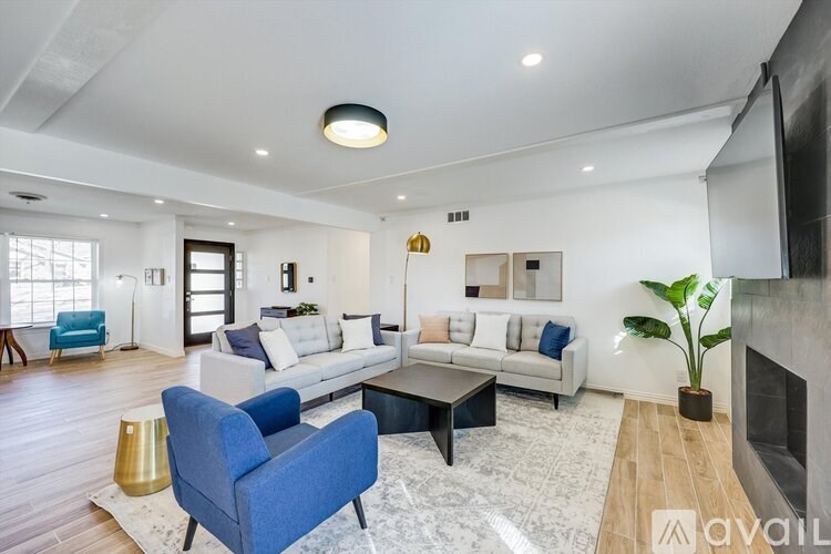 A living room with a blue chair and a white couch.