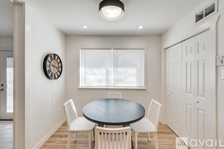 A dining room with a round table and chairs.