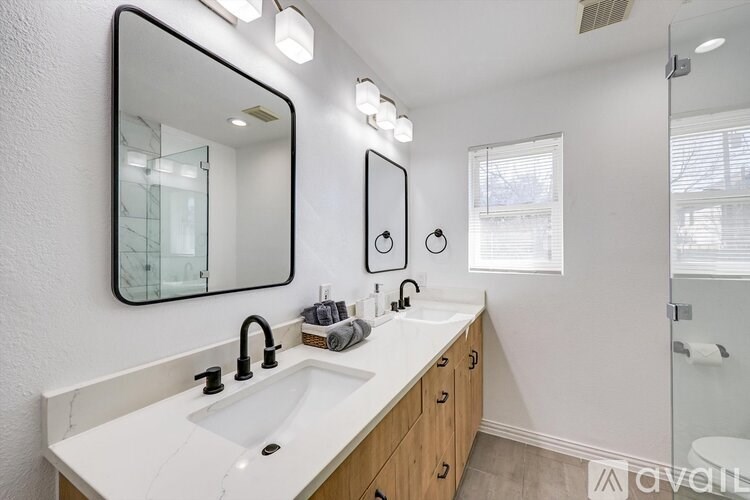 A bathroom with a white sink and a large mirror.