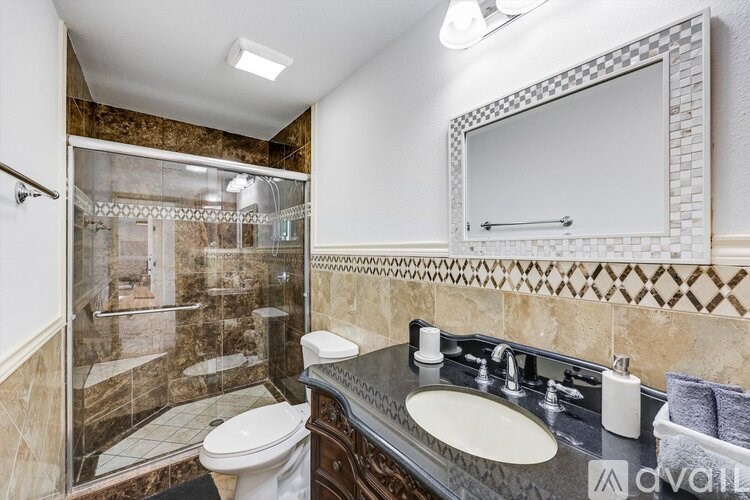 A bathroom with a toilet, sink, and shower.