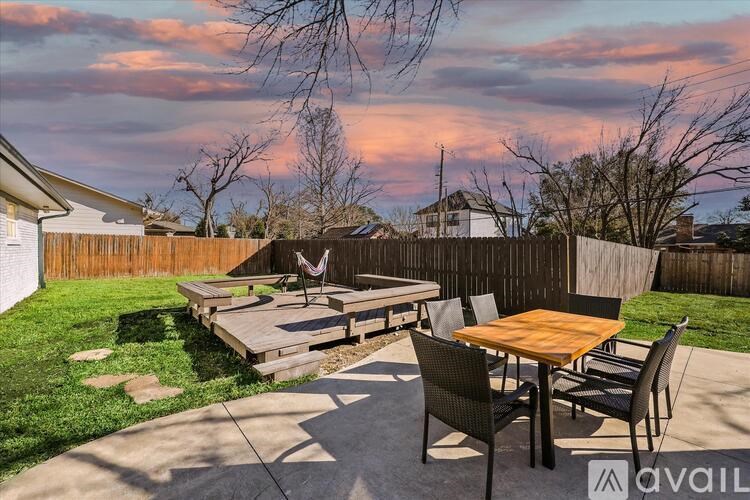 A backyard with a table and chairs is set up for an outdoor meal.