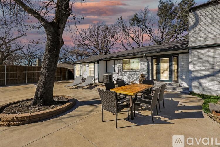A patio with a table and chairs is set up outside a house.