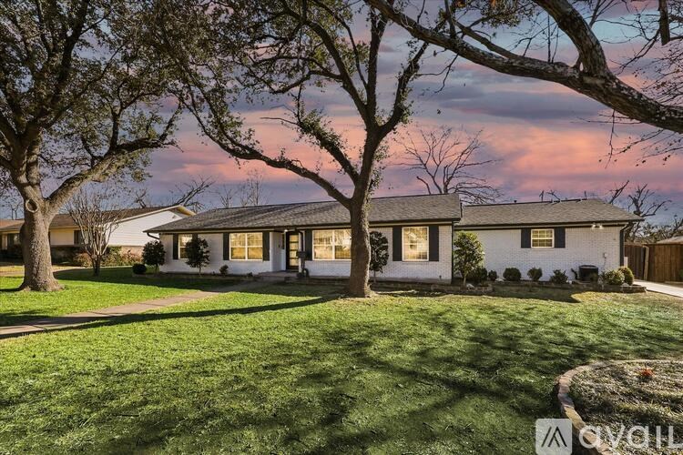 A white house with a tree in front of it.